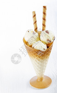 木头香草冰淇淋在白木背景的杯子上加面包饼晶圆奶油的图片