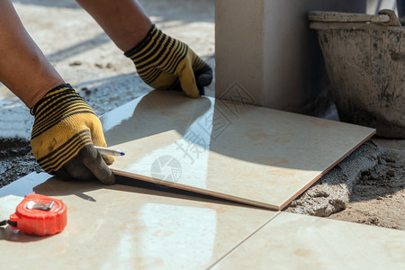 成人在建筑工程中安装瓷砖楼层镘石膏图片