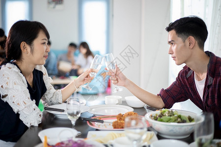 亚洲人享受浪漫晚宴夜饮的亚洲年轻夫妇坐在厨房餐桌旁一起吃饭时以软焦点为着眼坐爱图片