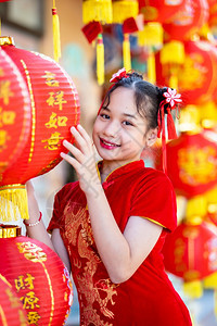 小可爱亚洲女孩穿着传统的青相红纸灯上面写着中文字母上帝保佑是财富祝福的赞美中华新年奖章幸运之福旅行假期文化图片