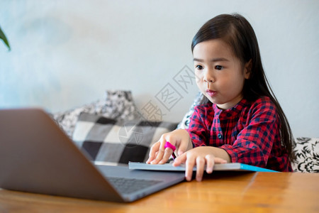 电脑亚洲女孩或儿利用笔记本和技术在学校假期间线学习和家里看漫画进行家庭教育概念和活动亚洲女孩或儿使用笔记及技术在学校放假期间线学图片