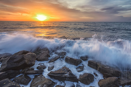 礁在黑海岩石岸线上景与多彩的日出天空和美丽波浪交织在一起早晨海浪图片