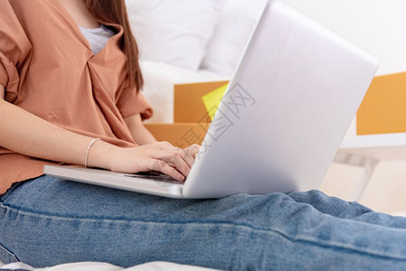 妇女利用膝上型计算机在家中线购物提供业务中关闭妇女使用的在线笔记本电脑在键盘上按手打女孩字人的生活和职业概念Jon企业家和店主题图片