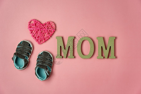 现代的平坦欢乐母亲节假日背景概念Flat平铺婴儿鞋和MOM在家庭办公室书桌式口音创意设计上关于现代美丽粉色纸的文字载于MOM妈图片