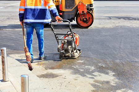 工作公路服务处积极使用旧的小型道路设备汽油振动式压板滚机以及旧的扫帚来铺沥青和修复小路段的沥青和修理A路工用汽油振动式压板过路机图片