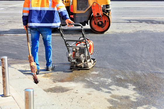 工作公路服务处积极使用旧的小型道路设备汽油振动式压板滚机以及旧的扫帚来铺沥青和修复小路段的沥青和修理A路工用汽油振动式压板过路机图片