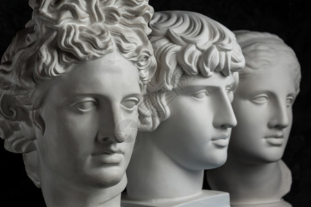 哲学神话象征古代阿波罗安提努斯和维纳雕像的白色石膏副本供艺术家在深色纹理背景上使用雕像脸石膏塑古代像阿波罗安提努斯和维纳头像的石图片