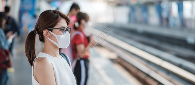 车站佩戴口罩的青年女游客图片