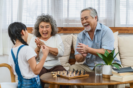 女儿居住亚洲夫妇祖父母和孙子一起玩象棋带着快乐的心情在一起欢庆和胜利长寿老年人社会温暖的家庭和幸福社交不融化的概念fn方正黑体简图片