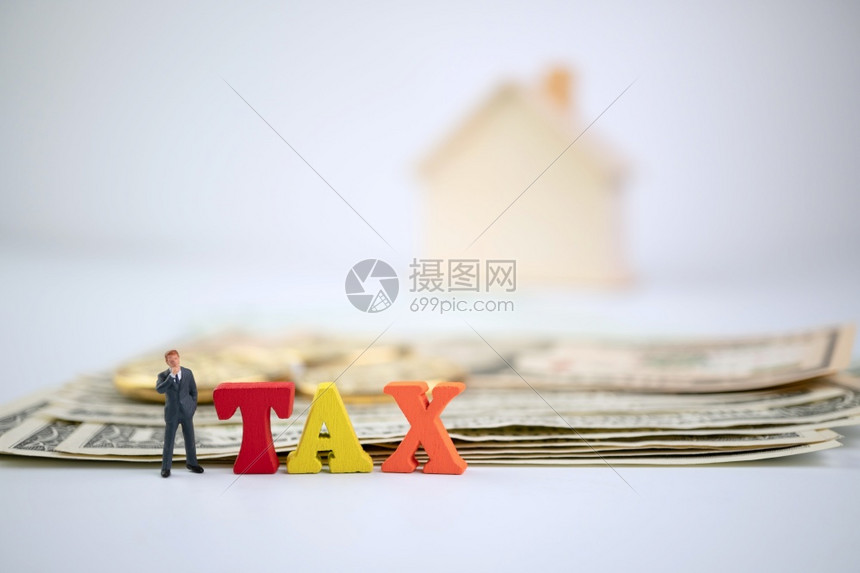 文件现金利润图与木材TAX字相对站立的商人钞票金币和木屋上的TAX字词背景纳税福利或强制金融收费的概念图片