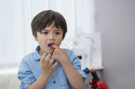 学前班眼睛在山上插手指的小孩头一牙摔掉后感到受伤动的孩子男独自站着思考面孔或神经保健心理康笑声常设图片