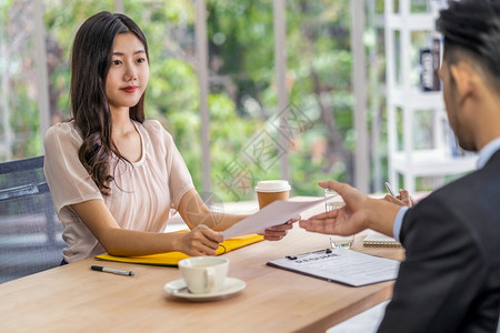 曼谷年轻亚洲女毕业生持有和向两名经理提交复职文件然后开始面试工作在会议室提出积极动企业雇用新成员概念商业公司聘用新会员概念Bus图片