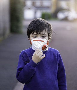 嘴身戴防污染或护面罩的婴儿混血亚裔6岁幼童天主教徒步行上学时戴着保护面罩的儿童Corona或Coronava概念组织以及第25页图片