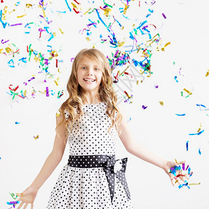 女孩跳起来欢乐地庆祝生日一个孩子的肖像扔出多彩色的锡轮和意面积极情绪快乐地笑着的孩子在闪亮口红淋浴下喜悦假期可爱的图片
