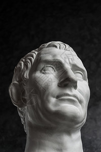 盖伊朱利叶斯凯撒屋大维奥古斯图老雕像的白石印副本画在黑暗纹理背景的人脸上艺术家头部面深色纹理背景的人脸部古老男复图片
