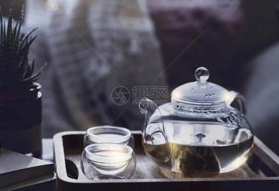 清爽净的茶壶和两杯个子在清晨光照亮的咖啡桌上餐盘装有轻蒸汽或可以作为下午茶水的可舒适场景用玻璃茶壶书包和锅炉加面粉优质的温暖图片