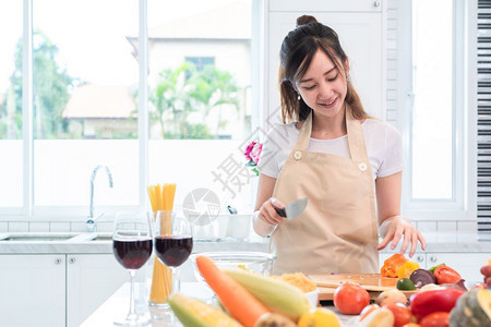 人们亚洲美女在厨房做饭和切菜把满食物和水果的放在桌上的假日和幸福概念人与生活方式概念家庭与晚宴主题人生活方式概念成人围裙图片