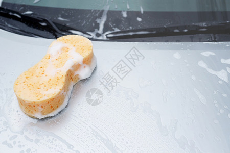 消息蓝色的泡沫洗车用黄色海绵和汽车上洗衣用的肥皂清洗汽车头罩被概念车清洁休假空间用于撰写信息图片