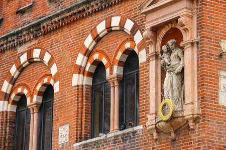 红色的意大利维罗纳PiazzadelleErbe的商人DomusMercatorum或CasadeiMercanti正面的雕像户图片