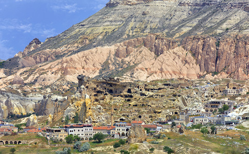 在土耳其中部现代定居点附近的卡帕多西亚古老董洞穴和土耳其中部红河谷卡帕多西亚的现代定居点附近一个特殊石块形成的一个古老山洞悬崖蓝图片