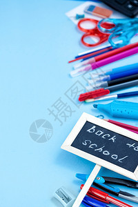 班级刀具返回学校概念笔记本和学校用品笔记本苹果书签笔薄饼剪刀脚笔蓝红黑和白色蓝背景图示齿轮图片
