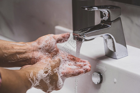 工作男人与铬水龙头和肥皂进行近身洗手在浴室预防科罗纳流行自我负责清洁手卫生冠状菌保护概念中防止科罗纳流行为了图片