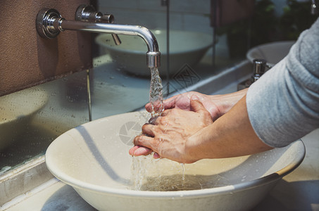 爆发与铬水龙头和进行近身洗手在浴室预防科罗纳流行自我负责清洁手卫生冠状菌保护概念中防止科罗纳流行健康脸盆图片