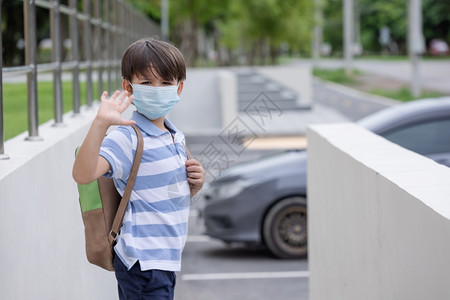 带着学校背包和防护面罩微笑着可爱的小男孩在科罗纳流行疾期间黑孩子回到学校上时为第一天的学校准备了保护面罩快乐的安全画图片