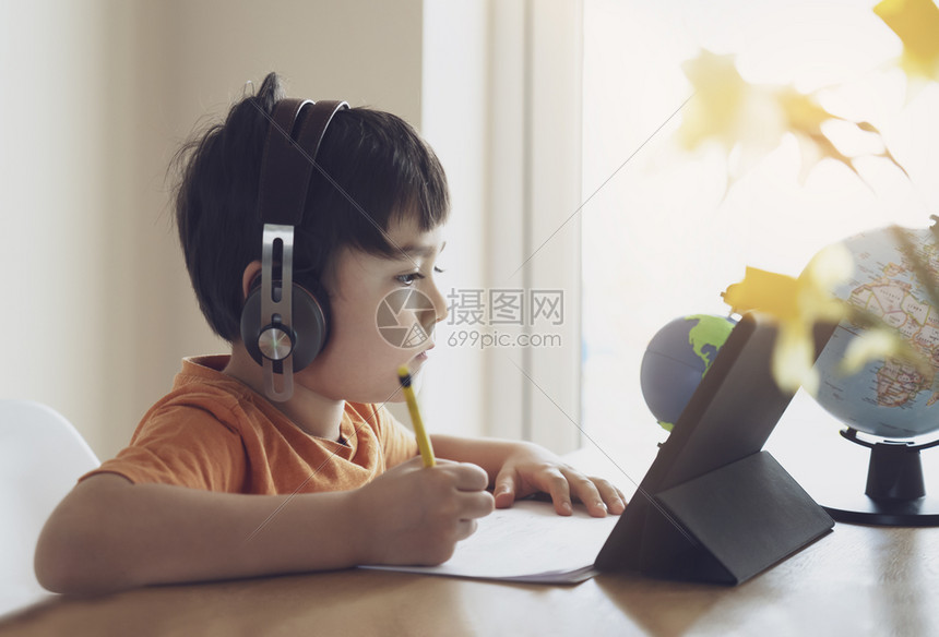 学龄前儿童使用平板电脑做功课儿童戴头部电话做功课在互联网上使用数字平板搜索信息家庭学校教育概念社会分化等的孩子停留图片