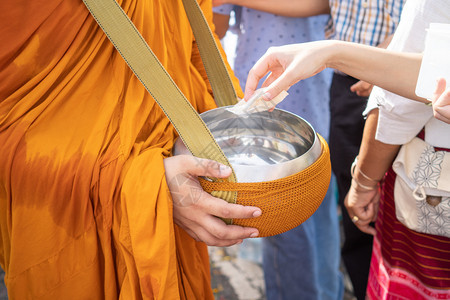 老挝佛教僧侣Sanghagivealms的僧侣与一位佛教和尚他于上午从佛教祭品中出来以表明信仰忠实地履行最近的职责仪式供品图片
