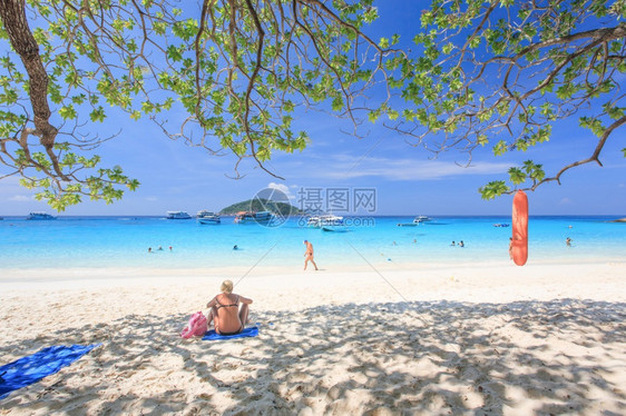 支撑夏季的西米兰群岛旅游女客在阳光和绿叶阴影下的白沙滩上放松绿树蓝色海水背景热带岛屿MuKoSimilan公园泰南部PhangN图片