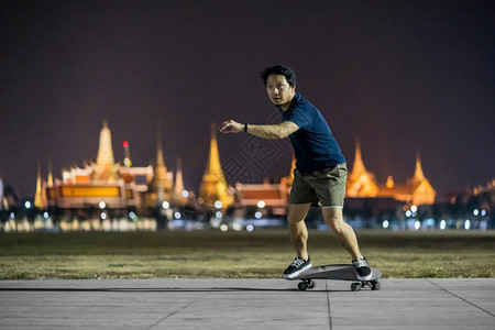 旅游极端晚上在户外公园玩冲浪skate或滑板的亚洲快乐男子照片模糊了曼谷大宫泰国低光极运动健康和锻炼时尚等概念19轮子图片