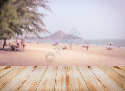 空木板桌顶上有模糊的热带海滨滩可用于补装或显示产品或者展示图片