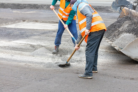 装修金属为了两名身穿明橙色反射背心的公路工人为翻新旧面准备了并在清理道路复制空间旧沥青后清除了废旧沥青之后将瓦砾搬入平板桶中2名图片