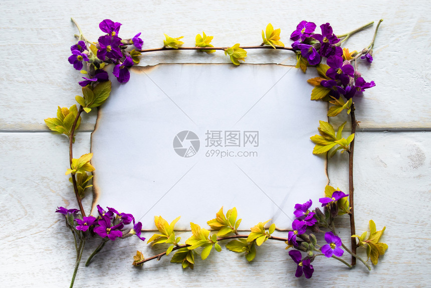 紫色的红平坦在白木板上有黄色床单和紫花的树枝在边缘烧着的一张白色纸片为文字留下空间概念在白色木板上有黄皮和紫花的树叶上一张白色纸图片