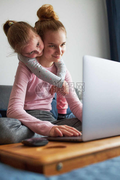 工作孩子们在COVID19隔离期间孙女和她的妹在家里笔记本电脑上与祖父母进行视频通话女孩坐在电脑前的床上姐图片