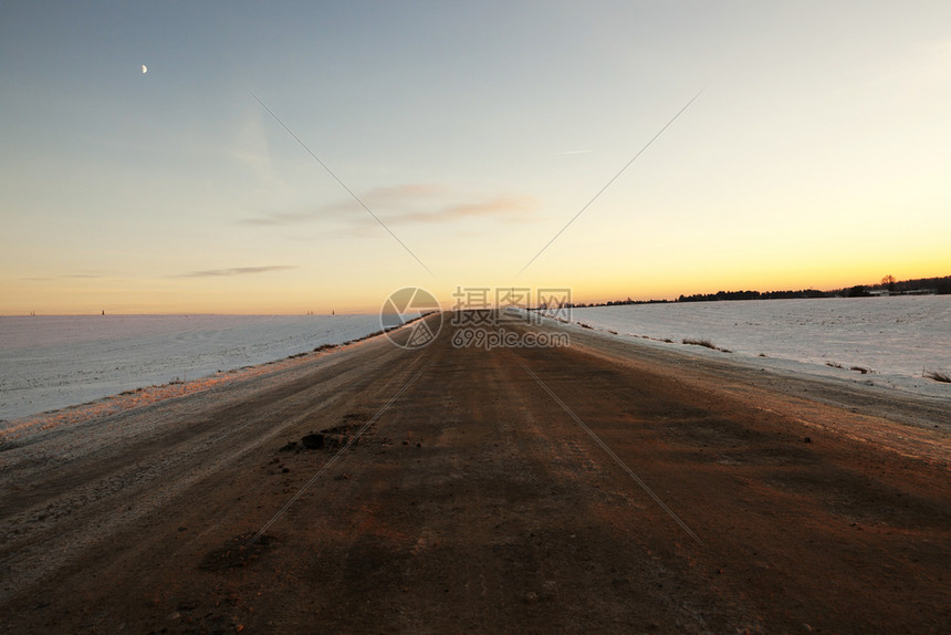 灾难户外超过道路上有很多泥土和地在一片雪覆盖的道路上被融雪压碎了的泥土和地一条铺着雪的公路上发生暴风雪图片