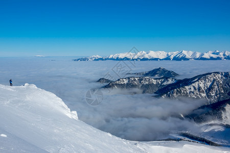 风景蓝色天空和雪峰上阳光明媚的天气山谷是浓雾孤独的旅游者拍摄着美丽的白花峰和峡谷中的雾游客最佳图片