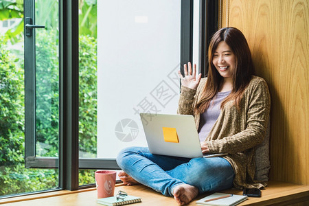 广告使用技术笔记本电脑的亚洲商业妇女在家工作打招呼或说再见自由职业和企家创造设计和博客社会距离和自我责任概念a利用技术手提电脑并图片