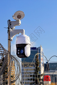 资料库盗窃罪带动传感器的录像摄机用铁丝网红色警告灯和照相机监测该地区安全周界以铁丝网红色警示灯和摄像机对侵入者进行防护垂直图像在背景图片