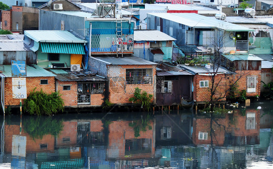 贫困城市HOCHIMINHCityVietNANSNNOV2107年河滨居民在晚上雨后住一组临时房从金属板或红砖下降为临时住房靠图片