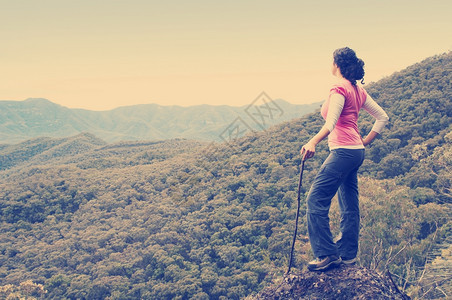 单身女远足者在山下看望着风景快乐的人们成功图片