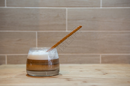 早餐甜的香气多层咖啡或卡布奇诺放在木制桌上的玻璃杯中面包干草多层咖啡或加卡布奇诺在装有面包稻的玻璃杯中图片