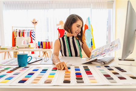 丰富多彩的从事计算机工作的亚洲青年设计师妇女在工作场所选择多色图表小企业创办主现代自由职生活概念和普通人在工作单位选择多彩图的亚图片