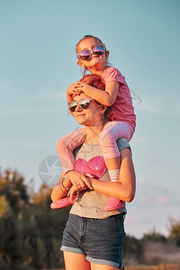 自由享受搭便车的姐妹们带着她的背抱着她肩膀一起在乡下Candid人户外玩耍真实的时刻情况还有真正的瞬间自然干草图片