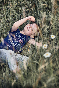 戳快乐笑的小女孩在乡下高草地玩耍坎迪德人真实的时刻情况日落快乐图片
