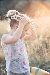日落小姑娘头上戴着野花真正的瞬间实情境身披鲜花的宝网时刻女孩幸福高清图片素材