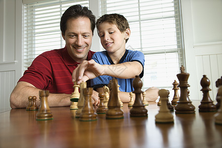 爸爸教儿子下象棋棋盘中年照片游戏娱乐父母两个人孩子男孩战略背景图片