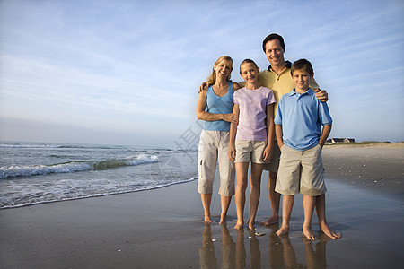 在海滩上微笑的家庭观众母亲女孩女儿海岸男子父母支撑青春期假期图片