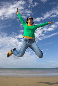 年轻美女在沙滩上跳跃了一大跳自由身体喜悦力量女性锻炼享受蓝色生活青少年图片